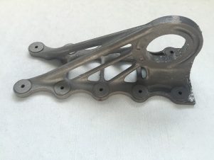 Vorher und nachher: 3D-gedruckte Metallteile wie dieses FCRC Bracket sind nach Druck noch porös und müssen für die weitere industrielle Fertigung poliert werden. Mit 3D SurFin wird die Polierung wasserbasiert und umweltschonend durchgeführt. So können 3D-gedruckte Teile bedenkenlos in der Serienproduktion eingesetzt werden – essentiell für die Nutzung des 3D-Drucks in der Luftfahrt und anderen Branchen. Damit gewinnt Airbus den IDL 2019 in der Kategorie „Smart Factory“. Bildquelle: Airbus