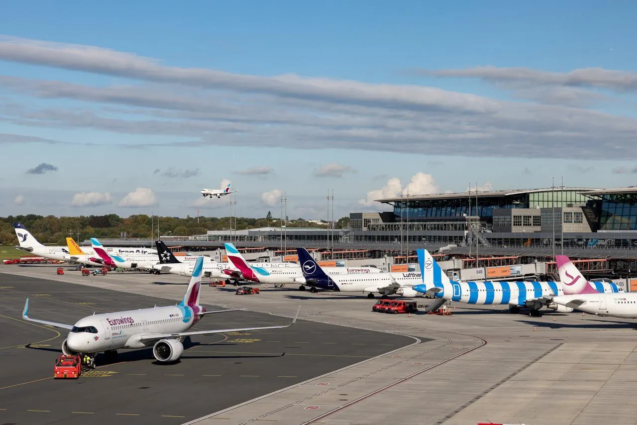 Verschiedene Flugzeuge stehen auf dem Flugfeld vor dem Flughafengbäude
